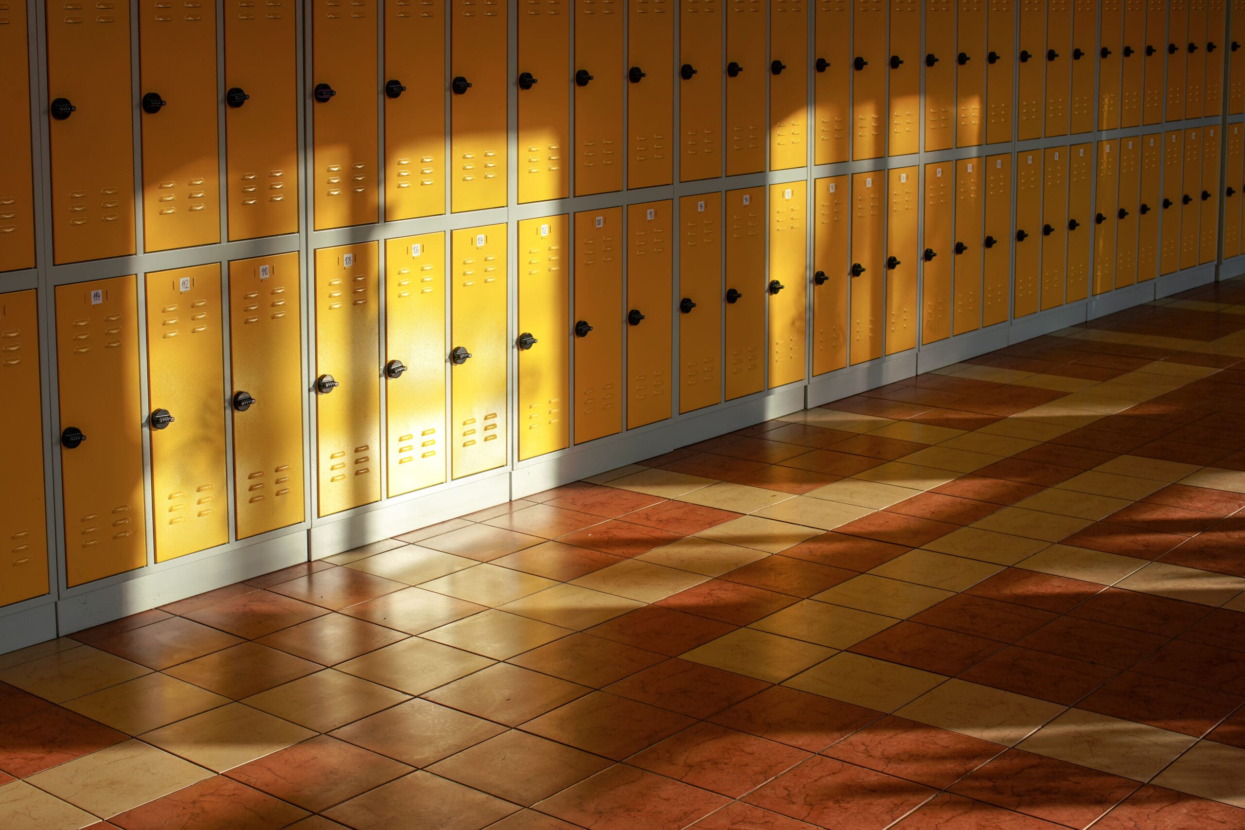 Skåp i skolkorridor där ljuset solljus skiner in.